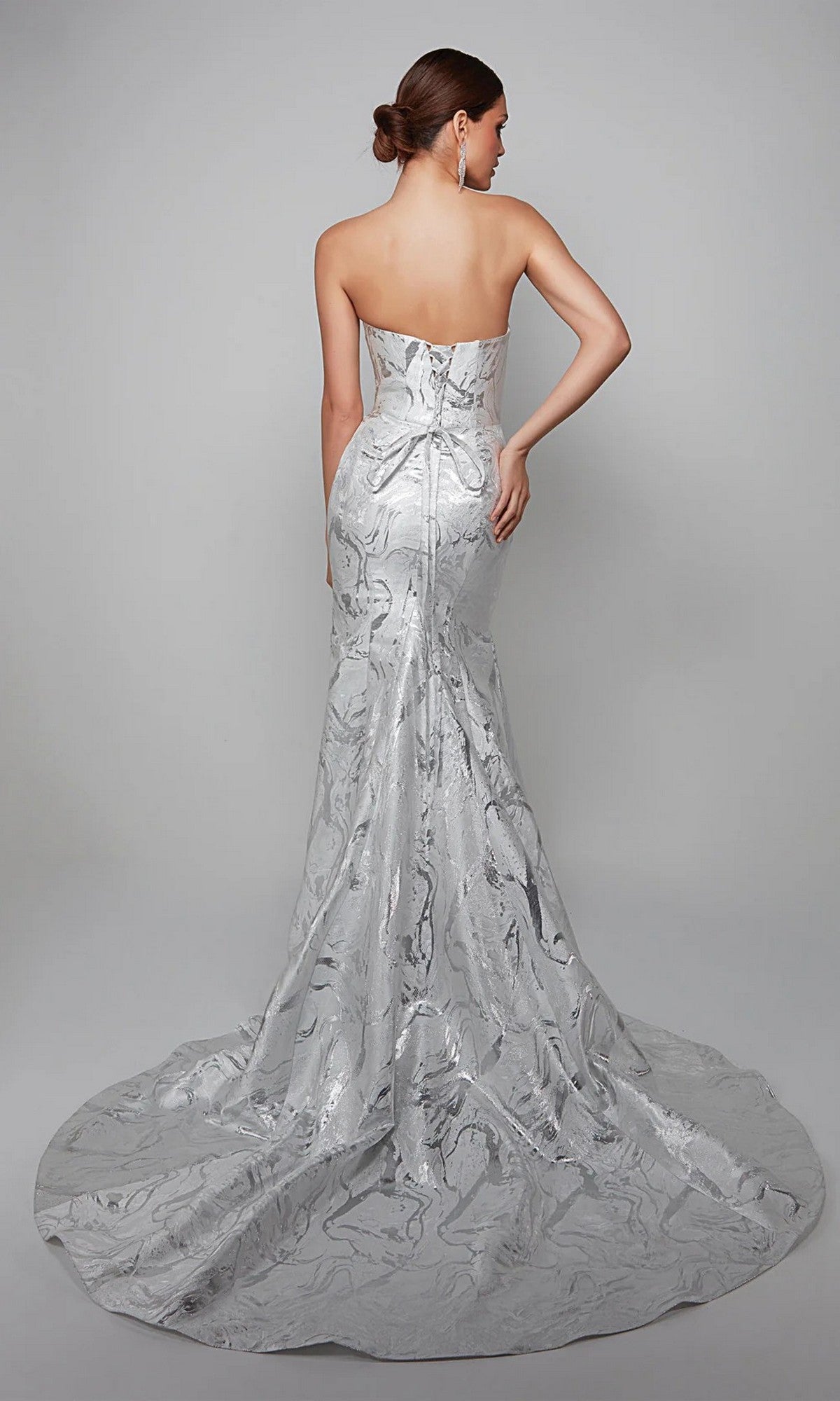 Woman in the Alyce 7055 Long White Dress, a strapless formal gown with a subtle marbled pattern, shown from the back against a gray background—an elegant choice for mother-of-the-bride or special occasions.